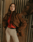 Faux suede single breasted blazer. Collar neckline. Front button closures. Front pockets. Long sleeves with faux button closures. Back slit. Fully lined. brown suede blazer.