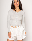 Ribbed knit top. Long sleeves. With elastic sleeve openings. Front button down closures. Unlined. Crochet lace trim. grey long sleeve