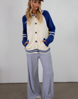 Colorblocked crochet knit cardigan. Crewneck. Long sleeves. Front button down closures. Front pockets. Unlined. ivory and blue sweater cardigan. fall top. fall sweater. oversized sweater