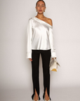 white Satin top. Folded off the shoulder neckline. Long sleeves with button closures. Unlined. white satin one shoulder top.