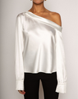 white Satin top. Folded off the shoulder neckline. Long sleeves with button closures. Unlined. white satin one shoulder top.