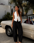 white Relaxed tailored fit halter top
Deep plunging halter neckline
Clean front paneling with center slit opening
Open-back design
Straight hip-length hem
Self-tie back closure with halter neck fastening
Unlined