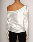 white Satin top. Folded off the shoulder neckline. Long sleeves with button closures. Unlined. white satin one shoulder top.