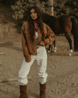 Tan brown faux suede jacket. Front zipper closure. Front and side pockets. Long sleeves with button closures. Fully lined. suede bomber jacket