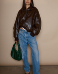 Faux leather jacket. Collar neckline. Long sleeves with elastic openings. Front zipper closures. Side pockets with snap button closure. Elastic hem. Fully lined. brown puffer jacket. brown puffer bomber jacket. fall jacket. bomber jacket. going out jacket