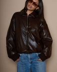 Faux leather jacket. Collar neckline. Long sleeves with elastic openings. Front zipper closures. Side pockets with snap button closure. Elastic hem. Fully lined. brown puffer jacket. brown puffer bomber jacket. fall jacket. bomber jacket. going out jacket