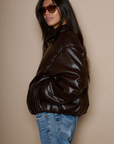 Faux leather jacket. Collar neckline. Long sleeves with elastic openings. Front zipper closures. Side pockets with snap button closure. Elastic hem. Fully lined. brown puffer jacket. brown puffer bomber jacket. fall jacket. bomber jacket. going out jacket