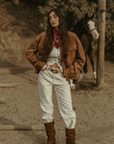 Tan brown faux suede jacket. Front zipper closure. Front and side pockets. Long sleeves with button closures. Fully lined. suede bomber jacket