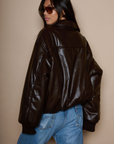 Faux leather jacket. Collar neckline. Long sleeves with elastic openings. Front zipper closures. Side pockets with snap button closure. Elastic hem. Fully lined. brown puffer jacket. brown puffer bomber jacket. fall jacket. bomber jacket. going out jacket