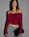 Knit crop top. Strapless elastic folded neckline. Front and back ruching. Long sleeves. Unlined. red off the shoulder long sleeve top. burgundy off the shoulder long sleeve top. holiday outfit. holiday look. christmas top. christmas outfit