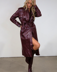 Faux leather trench coat. Collar neckline. Double breasted. Front button closures. Belted waist. Side pockets. Fully lined. burgundy faux leather trench coat. fall outfit. fall trench coat