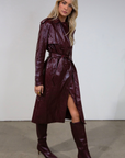 Faux leather trench coat. Collar neckline. Double breasted. Front button closures. Belted waist. Side pockets. Fully lined. burgundy faux leather trench coat. fall outfit. fall trench coat