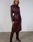 Faux leather trench coat. Collar neckline. Double breasted. Front button closures. Belted waist. Side pockets. Fully lined. burgundy faux leather trench coat. fall outfit. fall trench coat