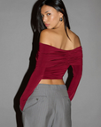 Knit crop top. Strapless elastic folded neckline. Front and back ruching. Long sleeves. Unlined. red off the shoulder long sleeve top. burgundy off the shoulder long sleeve top. holiday outfit. holiday look. christmas top. christmas outfit