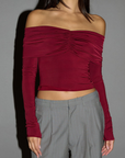 Knit crop top. Strapless elastic folded neckline. Front and back ruching. Long sleeves. Unlined. red off the shoulder long sleeve top. burgundy off the shoulder long sleeve top. holiday outfit. holiday look. christmas top. christmas outfit