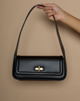 Vegan leather bag. Fixed top strap. Front twist latch closure. Fully lined. Inner pockets. 