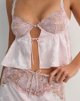 Pink satin sleep lingerie top
Open-front satin cami tank top
Sleek floral jacquard,
Adorned with lace trims, decorative bows, and a rosette at the center-front
Adjustable shoulder straps
Hook and eye closure at center-back
Unlined
Polyester/Elastane