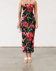 Floral printed knit mesh dress. Elastic strapless neckline. Inner rubber grip lining. Back slit. Black dress with large red floral.