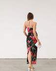 Floral printed knit mesh dress. Elastic strapless neckline. Inner rubber grip lining. Back slit. Black dress with large red floral.