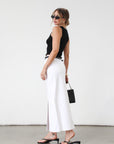 Denim midi skirt. Button and zipper fly. Five pocket construction. Front slit. Raw hem. Unlined. Relaxed fit that's designed to sit at the hips. No stretch. white denim maxi skirt. denim skirt with slit.