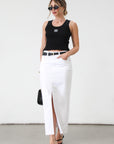Denim midi skirt. Button and zipper fly. Five pocket construction. Front slit. Raw hem. Unlined. Relaxed fit that's designed to sit at the hips. No stretch. white denim maxi skirt. denim skirt with slit.