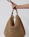 Straw woven bag. Vegan leather adjustable strap. Top zipper closure. Inner pockets. Fully lined. 