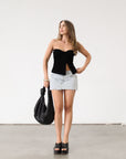 Knit Tube top. Elastic strapless neckline. Inner rubber grip lining. Ruched sides. Front slit. Unlined. Black tube top.