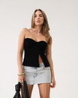 Knit Tube top. Elastic strapless neckline. Inner rubber grip lining. Ruched sides. Front slit. Unlined. Black tube top.