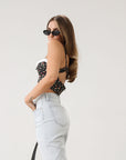 Floral printed woven cropped tank top. Adjustable straps. Boning in bodice. Elastic back strap with hook and eye closures. Back zipper closure. Fully lined.