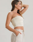 Ribbed knit tube top. Foldover elastic strapless neckline. Inner rubber grip lining. Unlined. Tube top. Ivory tube top. White tube top.