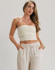 Ribbed knit tube top. Foldover elastic strapless neckline. Inner rubber grip lining. Unlined. Tube top. Ivory tube top. White tube top.