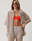 Open knit crochet shirt. Collar neckline. Short sleeves. Front button down closures. Unlined/sheer. Beach coverup. Pool coverup. Tan oat top