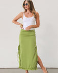 Satin maxi skirt. Side hook and eye and zipper closures. Side slits. Tie details. Lace trim. Fully lined. Green skirt.