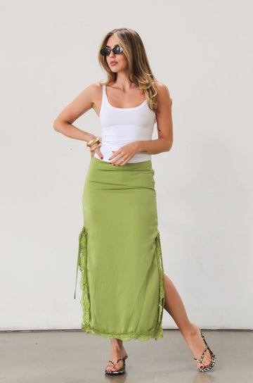 Satin maxi skirt. Side hook and eye and zipper closures. Side slits. Tie details. Lace trim. Fully lined. Green skirt.