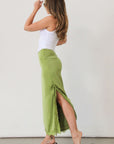 Satin maxi skirt. Side hook and eye and zipper closures. Side slits. Tie details. Lace trim. Fully lined. Green skirt.