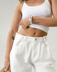 Wide leg jeans. Adjustable button waist closures. Button and zipper fly. Four pocket construction. Unlined. White jeans. White baggy jeans