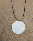 Cord necklace. Large round shell pendant. Adjustable lobster clasp closure.
