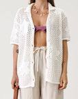 Open knit crochet shirt. Oversized fit. Collar neckline. Short sleeves. Front button down closures. Unlined. Beach shirt cover up. Pool shirt cover up. Vacation outfit. White crochet top.