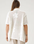 Open knit crochet shirt. Oversized fit. Collar neckline. Short sleeves. Front button down closures. Unlined. Beach shirt cover up. Pool shirt cover up. Vacation outfit. White crochet top.