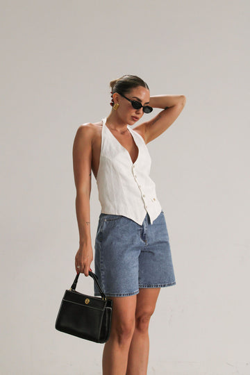 Denim shorts. Button and zipper fly closure. Five pockets. Unlined. High waisted, relaxed, wide leg, mid thigh length, non-stretch rigid denim. hemmed bottom.