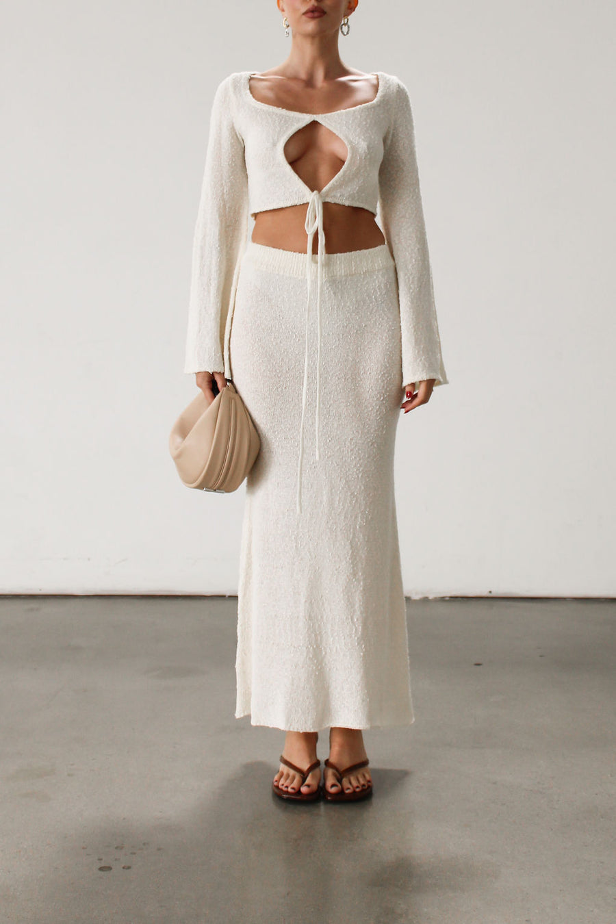 Cream maxi skirt set with long sleeve crop top.TOP: Textured crochet knit crop top. Long bell sleeves. Front keyhole and tie closure. Unlined  BOTTOM: Textured crochet knit maxi skirt. Elastic waist. Unlined.