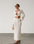 Cream maxi skirt set with long sleeve crop top.TOP: Textured crochet knit crop top. Long bell sleeves. Front keyhole and tie closure. Unlined BOTTOM: Textured crochet knit maxi skirt. Elastic waist. Unlined.