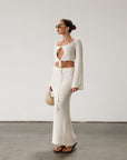 Cream maxi skirt set with long sleeve crop top.TOP: Textured crochet knit crop top. Long bell sleeves. Front keyhole and tie closure. Unlined BOTTOM: Textured crochet knit maxi skirt. Elastic waist. Unlined.