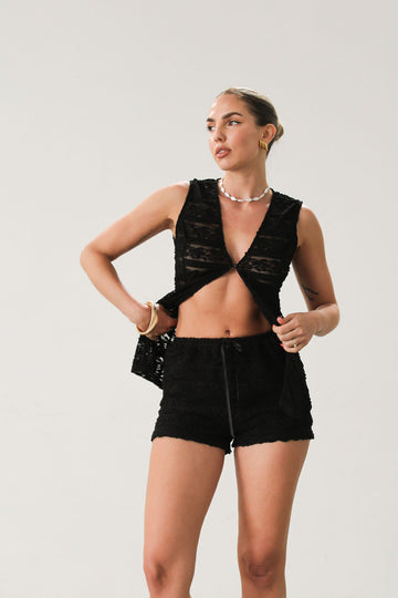 Ruffled knit lace shorts. Elastic waist. Front tie detail. Fully lined.