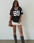 Mesh jersey t-shirt. V-neckline. Short sleeves. Side slits. Unlined/sheer. black jersey top. sporty casual outfit. summer top