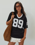 Mesh jersey t-shirt. V-neckline. Short sleeves. Side slits. Unlined/sheer. black jersey top. sporty casual outfit. summer top