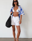 Printed woven shirt. Collar neckline. Short sleeves. Front button down closure. Unlined. cover up shirt. button up cover up. blue and white printed shirt. summer top. beach cover up. pool coverup