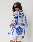 Printed woven shirt. Collar neckline. Short sleeves. Front button down closure. Unlined. cover up shirt. button up cover up. blue and white printed shirt. summer top. beach cover up. pool coverup