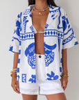 Printed woven shirt. Collar neckline. Short sleeves. Front button down closure. Unlined. cover up shirt. button up cover up. blue and white printed shirt. summer top. beach cover up. pool coverup