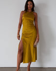 Satin maxi dress. Adjustable halter tie neckline. Side hook and eye and zipper closures. Front slit. Back tie closure. Partially lined. gold dress. gold midi dress. guest wedding dress. fall wedding.